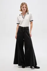 Pantalón jean de tiro alto y corte ancho tipo wide leg, con bolsillos y cierre frontal.