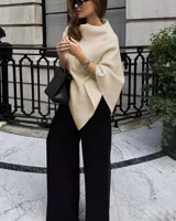Chal tipo capa color beige, de diseño amplio y asimétrico, con cuello alto.