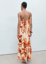 Vestido largo de viscosa con estampado de palmeras en tonos naranjas sobre base beige, escote halter con tirantes finos ajustables, diseño recto y bajo con volados.