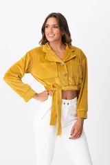 Campera corta color mostaza, con cuello tipo camisa, cierre frontal con botones, dos bolsillos de parche en el pecho y lazo para atar en la cintura.