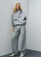 Pantalón de vestir estilo jogger con tiro medio, bolsillos laterales y cierre oculto. Presenta un diseño largo de corte recto y forro interior.