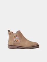 Botin de cuero serraje color beige, con elastico lateral decorado con bordado floral multicolor y suela baja de goma.