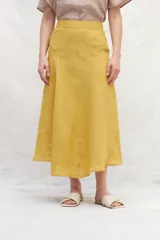 Falda midi color mostaza, de lino, con corte evasé y cintura alta.