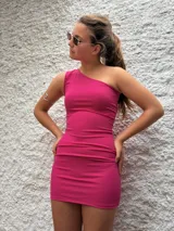 Vestido corto fucsia de crepe, con un solo hombro y corte ajustado al cuerpo.