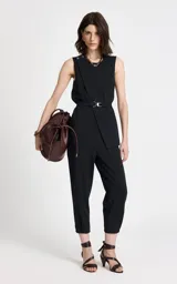 Pantalón sastrero de corte recto y tiro alto, confeccionado en tejido de punto con estampado de raya diplomática. Presenta cintura estructurada con trabillas, pliegues frontales, bolsillos traseros de ribete y cierre frontal con cremallera y corchetes.