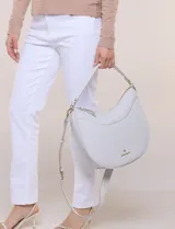 Cartera de hombro de silueta semicircular, marca Nanette Lepore. Modelo amplio de estructura flexible y diseño sofisticado, confeccionada en cuero sintético de textura graneada. Cuenta con cierre principal superior, asa corta integrada y correa larga cruzada regulable y desmontable. Presenta detalle de costura ornamental curva en el frente y logo metálico dorado aplicado en la parte inferior.