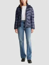 Campera acolchada de poliamida con diseño plegable, cierre frontal con cremallera, bolsillos laterales y capucha integrada.
