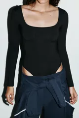 Body de manga larga con escote cuadrado, confeccionado en tejido elástico con cierre inferior mediante botones a presión.