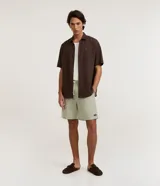 Bermuda masculina de sarga color verde claro, con cintura elástica, cordón de ajuste crudo y bolsillos laterales.