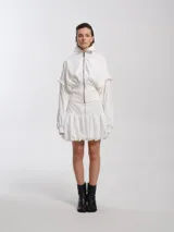 Campera bomber blanca con cuello alto, cierre frontal, faja ancha en la cintura y mangas largas desmontables.