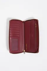 Billetera grande de nylon color negro con cierre perimetral de cremallera. Presenta un tirador de cordón bicolor con terminales metálicos y el logo de la marca estampado en dorado en el frente.