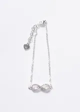 Pulsera de plata 925 con diseño de infinito adornado con zirconias, cadena de eslabones y cierre mosquetón con extensión terminada en un pequeño dije de corazón.