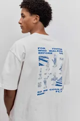 Remera de algodón color gris oscuro, de corte holgado y manga corta, con un pequeño estampado gráfico en el pecho.