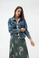 Campera de denim azul con bolsillos frontales con solapa, cuello clásico y cierre de botones metálicos.