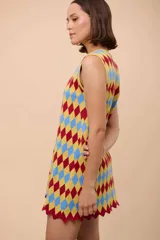 Vestido corto sin mangas con estampado de rombos en azul, rojo y amarillo. Tiene escote con forma de gota y terminación en picos.