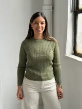 Sweater de punto con diseño de trenzas verticales, cuello redondo y mangas largas, en color verde oliva.