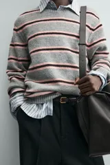 Sweater de punto con diseño de rayas horizontales en tonos gris, rosa y marrón. Presenta cuello redondo, manga larga y terminaciones en rib acanalado.