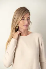 Buzo color verde azulado de tejido de punto fino con frente acanalado y bolsillo con botón de strass.