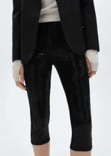 Leggings capri de corte skinny, confeccionados en tejido cubierto de lentejuelas negras. Presentan una cintura con elástico para un ajuste cómodo y un diseño sin cierre.