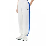 Pantalón de jogging blanco de corte recto con cintura elástica y cordón ajustable. Presenta una franja azul a lo largo de la pierna y el logo de Lacoste bordado en el muslo.