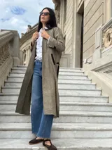 Tapado largo de paño liviano con diseño de cuadros en tonos marrones. Presenta solapas clásicas, bolsillos laterales con detalles en cuero y tajos profundos en los costados.