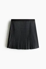Minifalda plisada de corte evasé, en color negro, con cintura elástica de ribete oscuro y sutiles líneas contrastantes.