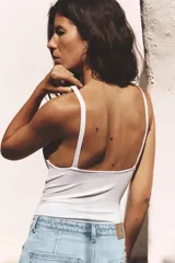 Body negro de tejido texturizado, con escote en V pronunciado y tirantes anchos.