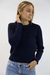 Sweater azul marino de punto con diseño de trenzas o espigas en relieve, cuello redondo y mangas largas con puños y dobladillo acanalados.