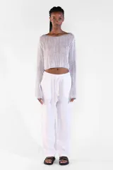 Sweater crop plateado de manga larga, tejido con hilo brillante con lurex, escote bote amplio y diseño relajado.