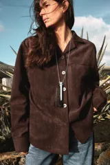 Sobrecamisa de tejido efecto ante en color marrón, con cuello solapa, manga larga con puños y cierre frontal de botones. Presenta un bolsillo de plastrón en el pecho.