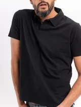 Remera tipo polo de manga corta con textura cloqué en color gris, de corte clásico y cuello camisero con abertura frontal.