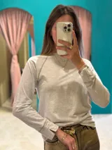 Remera blanca de corte clásico con mangas largas y cuello redondo.