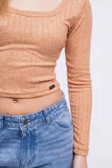 Remera corta color marrón con estampado animal print de leopardo, escote asimétrico y manga larga.