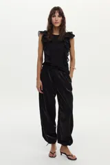 Pantalón estilo babucha de tafeta negra, con cintura elástica y puños ajustables en los tobillos.