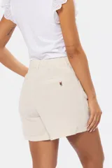 Short de lino color beige, de diseño liso con media cintura elastizada, bolsillos laterales y bolsillos traseros ojal con detalle de tira.