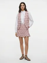 Chaleco sastrero de tejido plano con estampado tweed en tonos rosados, negros y blancos. Diseño sin mangas con corte regular.