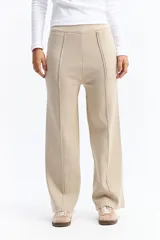 Pantalón de punto de tiro medio con corte recto y fit relajado. Presenta costuras verticales frontales que estilizan la silueta y bolsillos laterales.