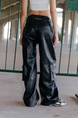 Pantalón de ecocuero negro, corte ancho, con bolsillos laterales y traseros, y cintura elástica en la parte posterior.