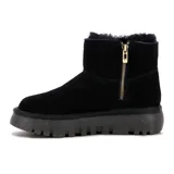 Bota corta de cuero color negro, de estilo invernal con interior y reborde superior de corderito sintético negro. Cuenta con suela gruesa track y un aplique triangular de goma con la inscripción 'Country' en el lateral.