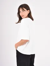 Remera de algodón color negro, con cuello redondo, corte holgado y mangas cortas con dobladillo ancho.