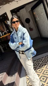 Campera de jean de corte recto y calce relajado, confeccionada en denim 100% algodón. Combina distintos tonos de azul con bordados exclusivos de Sierra Mora y detalles inspirados en la bandera uruguaya.