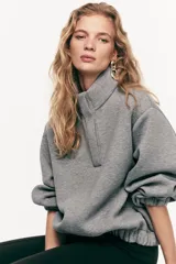 Buzo de corte holgado en tejido con efecto neopreno, con hombros caídos, cuello elevado y tapeta frontal con botones a presión ocultos. Presenta puños y bajo con elástico revestido.