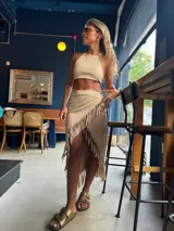 Pollera midi color beige con flecos en diagonal.