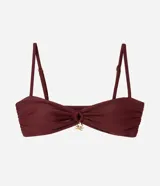 Top de bikini bandeau de microfibra color bordó, con fruncido delantero, tirantes finos regulables y un dije metálico dorado en el centro.