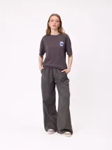 Pantalon de gabardina de corte recto y pata ancha, con cintura elástica y etiqueta decorativa en el frente.