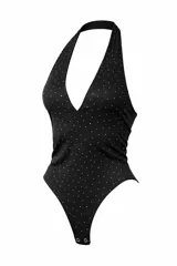 Body negro con escote halter profundo y estampado de pequeños puntos blancos que simulan strass. Presenta cierre inferior con broches.