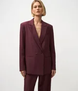 Blazer femenino color bordó, de corte oversized y caída recta. Presenta cierre traspasado con dos botones delanteros, mangas largas, cuello con solapa tradicional y bolsillos delanteros con acabado incorporado. Cuenta con forro interno.