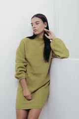 Vestido corto de punto color fucsia, con cuello alto y mangas largas amplias. Diseño holgado y cómodo.