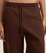 Pantalón de jogging marrón de algodón con forro de polar, corte amplio tipo barrel, cintura elástica con cordón de ajuste y bolsillos laterales.