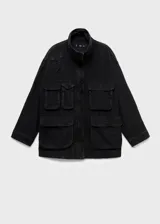 Anorak de estilo utilitario confeccionado en tejido de algodón tipo denim, con diseño oversize, cuello embudo, cierre frontal de cremallera y botones a presión, y cuatro bolsillos de parche con solapa en la parte delantera.